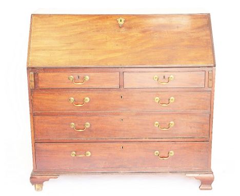 A George III mahogany bureau, with fall enclosing a fitted interior, above two short and three graduated long drawers, on oge