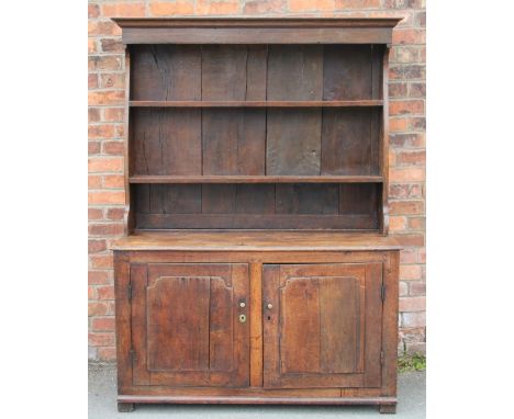 A late 18th century provincial oak dresser, the three shelf plate rack with 'pot belly' sides, above two panelled cupboard do