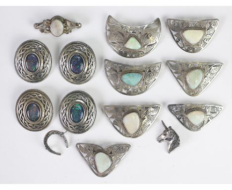 A quantity of brooches and brooch/pendants set with opal triplets, doublets and natural opals, each stone within decorative w