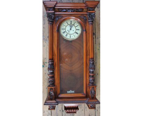A walnut Vienna regulator, enamel chapter ring with Roman numerals and subsidiary seconds, with twin weight movement striking