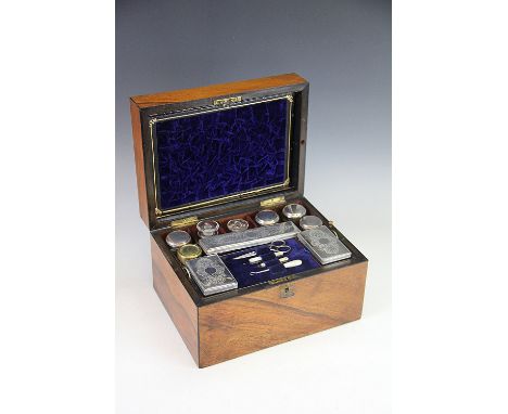 A Victorian walnut fitted dressing case, the interior enclosing assorted dressing table jars, manicure tools etc, with blue v