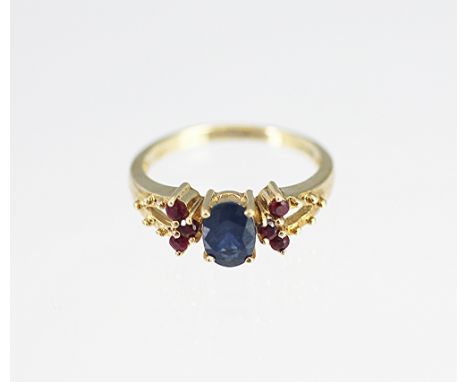 A sapphire and ruby ring in 9ct yellow gold, designed as a central sapphire, flanked by three rubies to either side, with ope