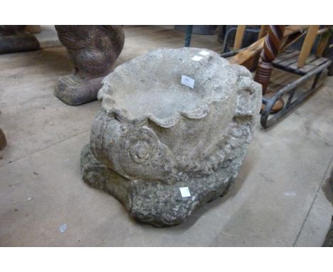 A concrete garden shell shaped planter 