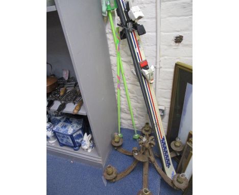 A pair of skis and poles together with a vintage ceiling light 