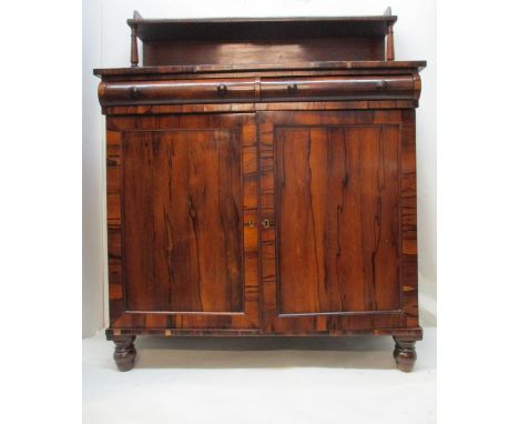 An early 19th century rosewood chiffonier, the upstand with a shelf, over two cushioned drawers and a pair of panelled doors,