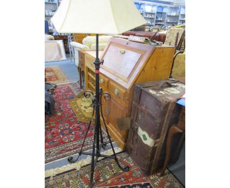 A mid 20th century black painted wrought iron standard lamp with later cream shade 