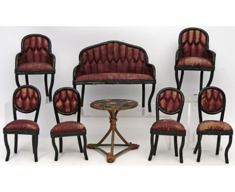 Sitzgruppe für die Puppenstube, 8-teilig. Schwarz gelacktes Holz, Seidenpolsterung teils zerschlissen. Bestehend aus: Sofa, 2