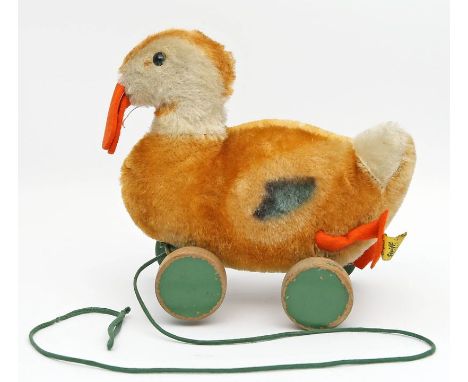 Nachziehente, Steiff. Verschiedenfarbiger Mohair, Holzräder. Mit K und F. Bespielt und Stimme defekt. 50er/60er Jahre. H. 16,