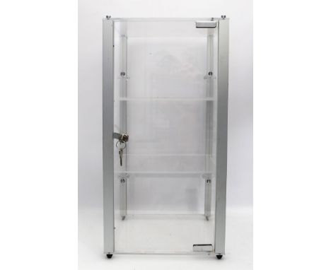 Kleine Vitrine. 4 senkrechte, matte Aluminiumstreben, Seiten, Rückwand, Boden, Deckplatte und Tür aus Plexiglas. 2 Plexiglase