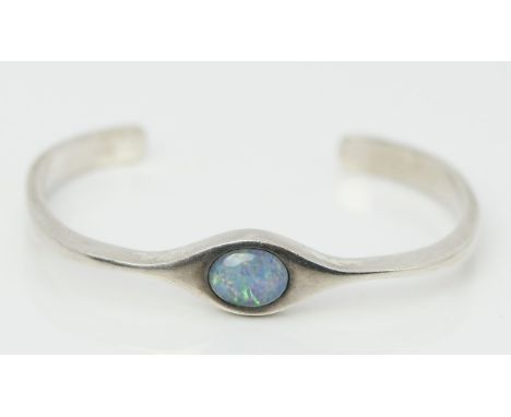 Armspange. 835/000 Silber, 14,5 g. Besetzt mit ovaler Opal-Triplette. B. 1, D. ca. 4x 5,2 cm.