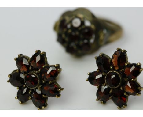 Granatring und Paar -ohrstecker. a) Ring. 333/000 GG, brutto 2,6 g. Besetzt mit 7 rund facettierten Granaten. RW 51 und b) Oh