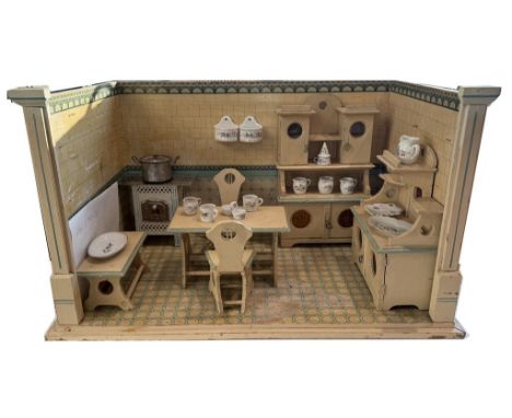 Puppenküche. Tapeziertes Holzgehäuse. Eingerichtet mit Buffet, Tisch, 2 Stühlen, Blechherd, etc. Beigegeben: Einige Zubehörte