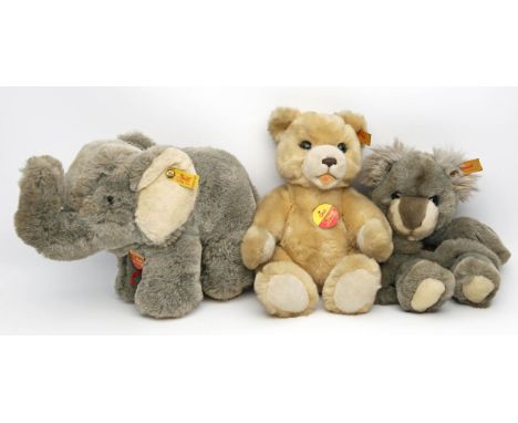 2 Steiff-Tiere und Steiff-Handpuppe: Elefant "Cosy Trampy", Teddy "Orsi" und Panda "Happy". Je mit Knopf, Fahne und Schild. U