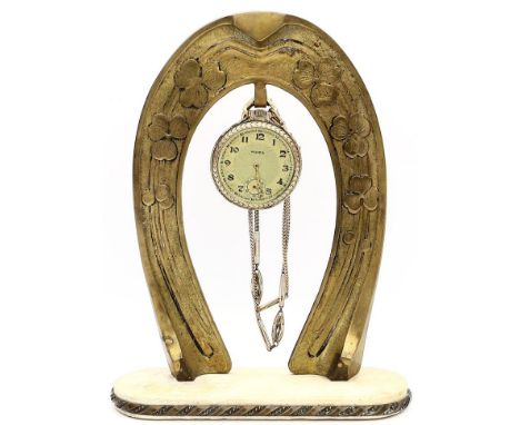 Jugendstil-Taschenuhrhalter. Messing mit floralem Reliefdekor, Steinsockel (rep.). Um 1900. H. 21 cm. Beigegeben: Taschenuhr 