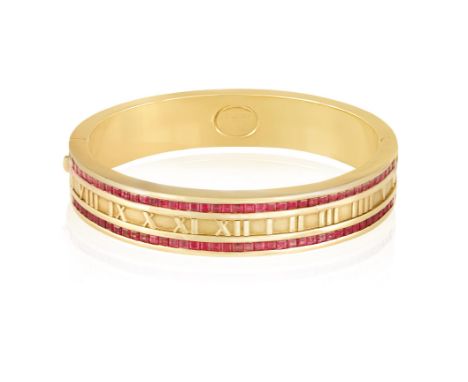 A RUBY-SET 'ATLAS' BANGLE, BY TIFFANY & CO., 1995The hinged bangle with Roman numerals in relief, the frontispiece set with c