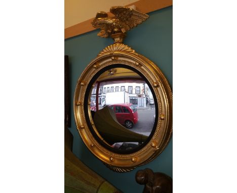 A Regency Style Gilt Convex Mirror with Eagle Finial.