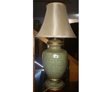 A Good Quality Green and Gold Patterned Ceramic Table Lamp; with yellow silk shade.