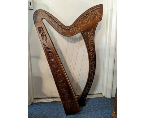 A wooden knee harp with twenty seven strings and carved ornament in a soft carrying case, 89cm highLocation: 