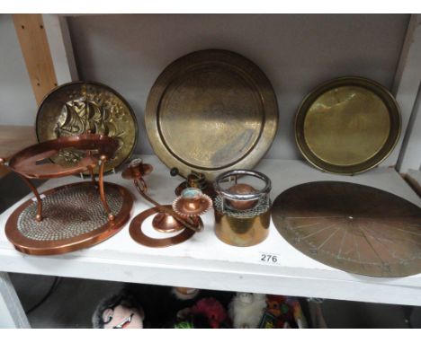 A shelf of brass and copperware including sundial etc