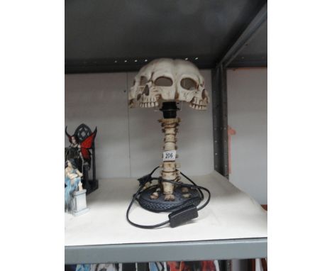 A lamp in the form of a human spine with a skull shade