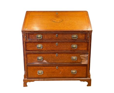 A 19th century inlaid oak fall front bureau, with four graduating drawers below with brass swing handles, raised on shaped br