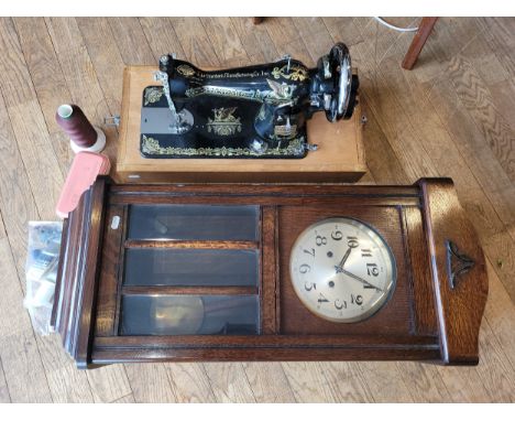 An early 20th century manual sewing machine, made by 'The Standard Manufacturing Co. Inc.' together with an oak cased wall cl