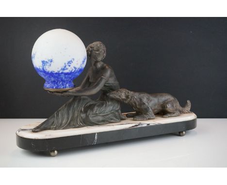 Art Deco Lamp in the form of a Spelter Lady with a Dog holding a glass speckled blue shade, raised on a pink and black marble