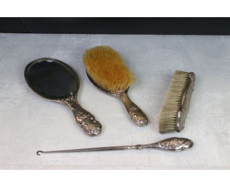 A fully hallmarked sterling silver vanity set to include two brushes, hand mirror and button hook all with repousse Reynolds 