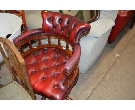 A red leather button down upholstered desk chair 