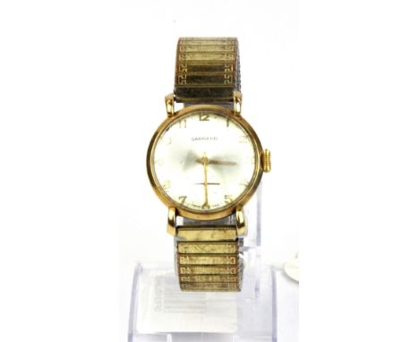 A gent's vintage 9ct gold Garrard wrist watch on an expanding gold plated strap.