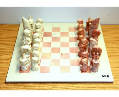 A carved stone chess set, king H. 13cm.