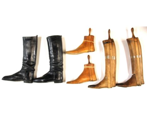 A pair of vintage leather boots with wooden boot trees and pair of wooden shoe trees.