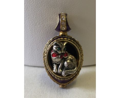A silver gilt guilloche enamelled cat pendant. Egg shaped with purple enamel and set with crystals. Measures approx 3cm to th