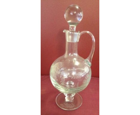 A vintage glass footed decanter with engraved decoration  