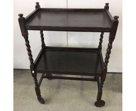 A dark wood vintage tea trolley with barley twist legs.  Approx. 61cm x 84cm.