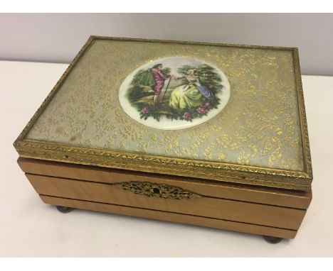 A vintage Swiss musical jewellery box with Limoges style plaque on the lid. Thorens musical movement in working order. Contai