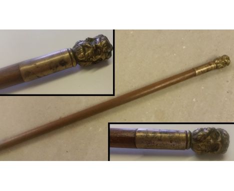 A brass topped vintage walking stick. With classical head design to top. Approx. 103cm long