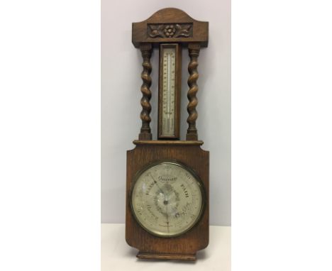 A vintage wooden framed and cased barometer & thermometer. With barley twist column detail.  Barometer marked C.S.S.A Ltd, Lo