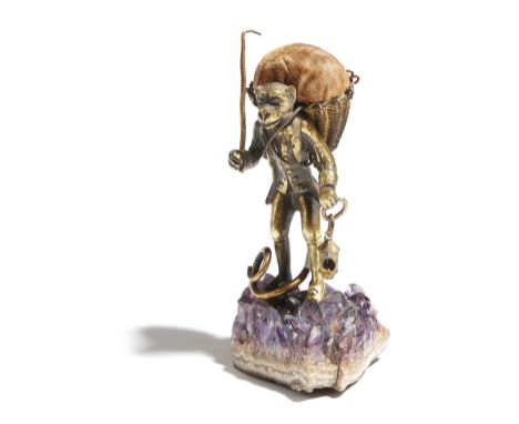 A 19th century gilt metal pin cushion, in the form of a well dressed monkey carrying a lantern and with a wicker basket on hi