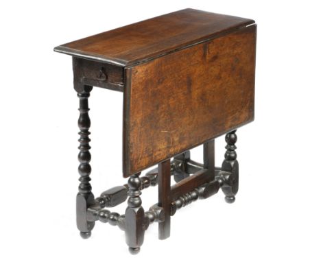 An early 18th century oak gateleg table, the single drop-leaf top on baluster ring and bobbin turned legs, united by peripher