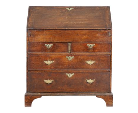 A George II oak bureau, the hinged fall revealing pigeonholes and drawers, with a central cupboard and with a sliding well co