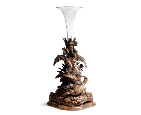 A late 19th century Black Forest limewood centrepiece, carved with a tree trunk, leaves and two birds, issuing a glass vase, 