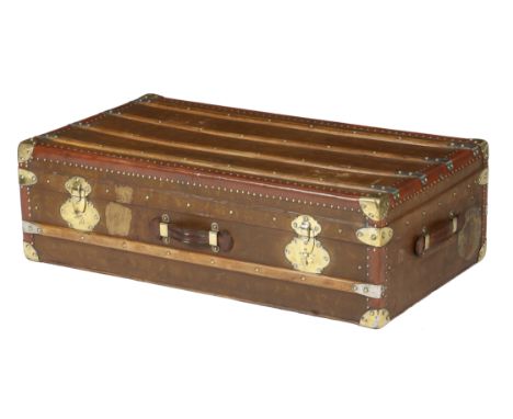 A canvas and leather trunk in Louis Vuitton style, brass studded and with gilt metal mounts, with a vacant interior, 30.4cm h