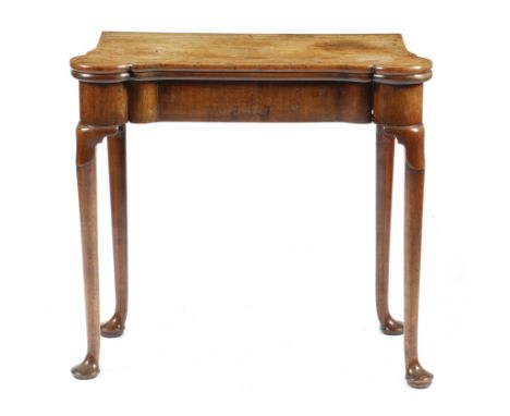 A George II red walnut card table, the hinged top with eared corners revealing a baize lined interior with candlestands and c