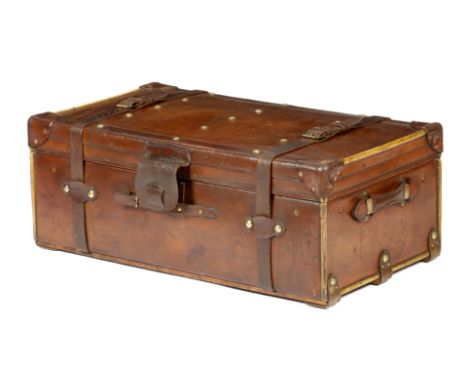 A brown leather trunk by Finnigans, brass studded, the interior with a lift-out tray, with a maker's label inscribed 'FINNIGA
