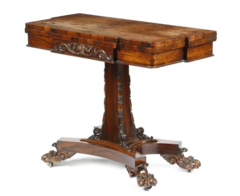 λ&nbsp;A William IV rosewood card table, the breakfront hinged and swivel top above a frieze carved with scrolling leaves and