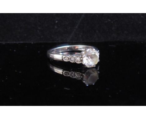 A white gold ring with central clear stone and diamond set shoulders, stamped 18ct. Size N, 3.8g