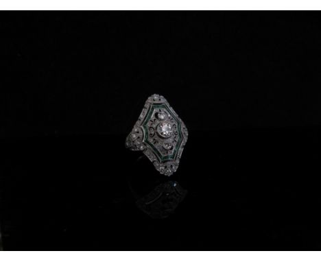 An Art Deco style platinum emerald and diamond ring, the central diamond in rub over setting in an openwork design and milgra