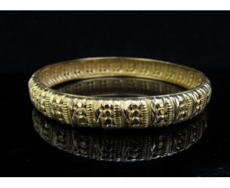 An Indian gold ornate bangle with pierced and cut design, 17.6g