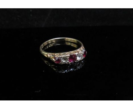 An 18ct gold five stone ruby and diamond ring. Size N, 2.2g